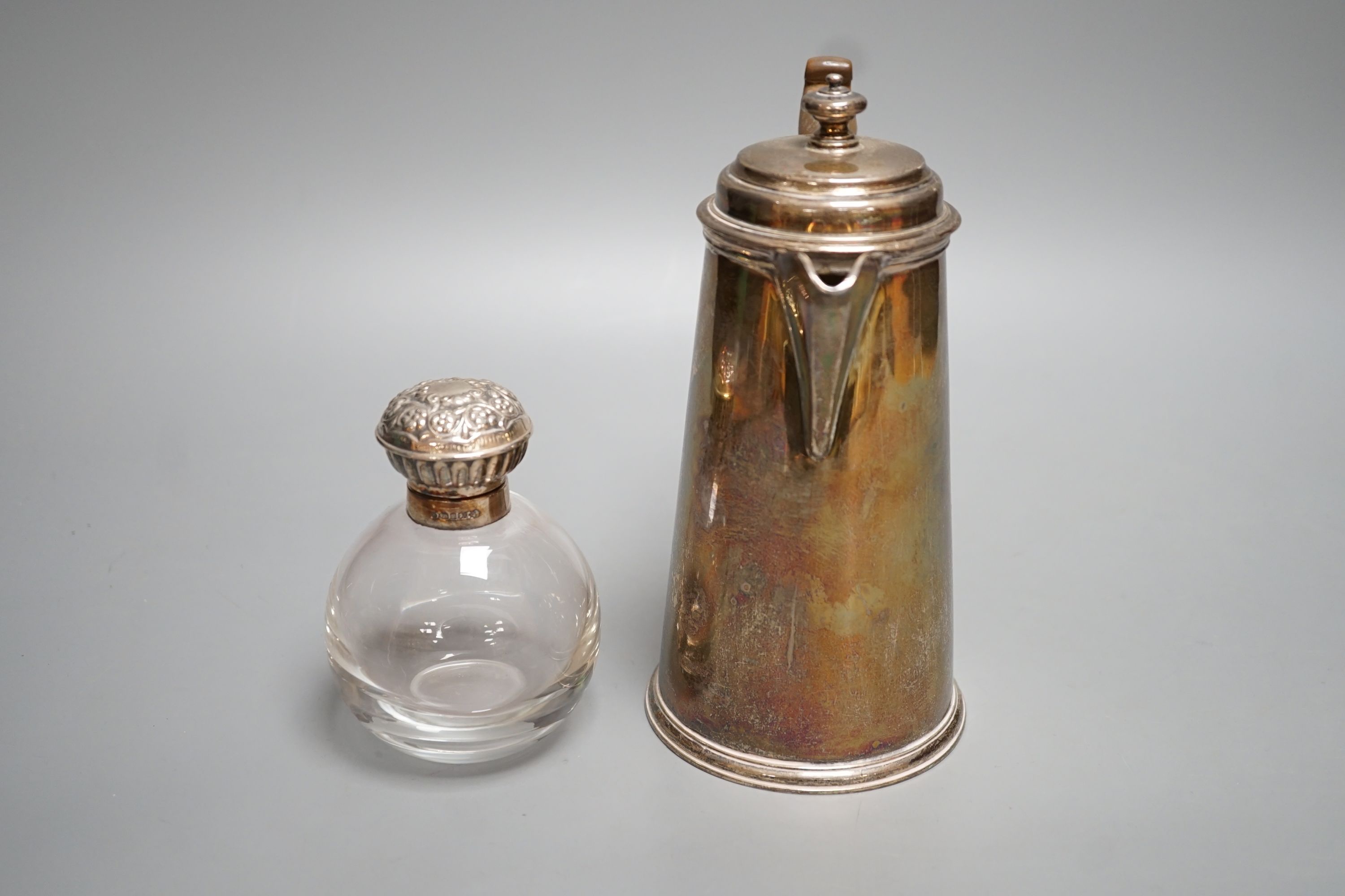 A George V silver hot water pot, London, 1934, gross 15oz and a silver topped glass scent bottle.